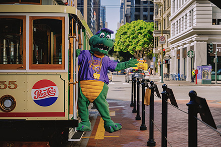 SFSU mascot Ali Gator poses on a cable car in San Francisco’s Financial District.